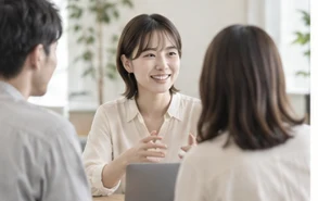 職場で資料を囲み、打ち合わせをする人たち